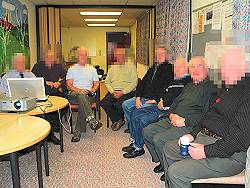 Photo of older men at a club - faces blurred for anonymity.